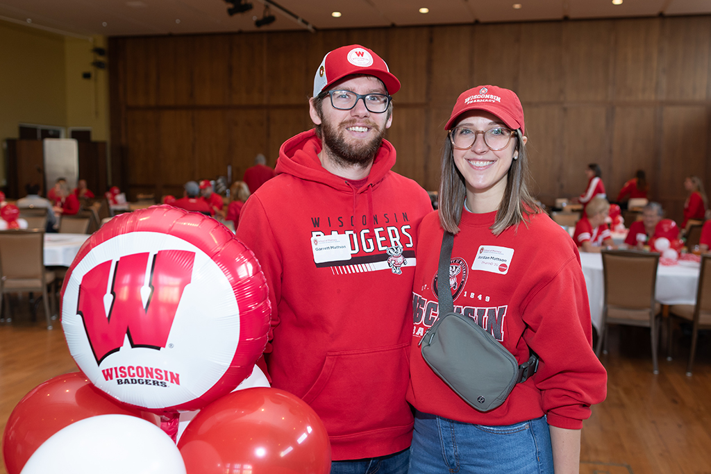 UW–Madison School of Pharmacy 2024 Alumni Tailgate and Watch Party Garrett and Jordan Mattson pose for a photo in Badger gear