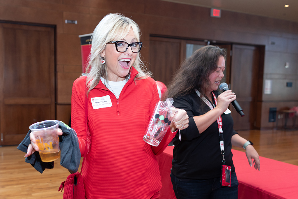 UW–Madison School of Pharmacy 2024 Alumni Tailgate and Watch Party Beth Margin holds up a Karben 4 glass she won through the raffle