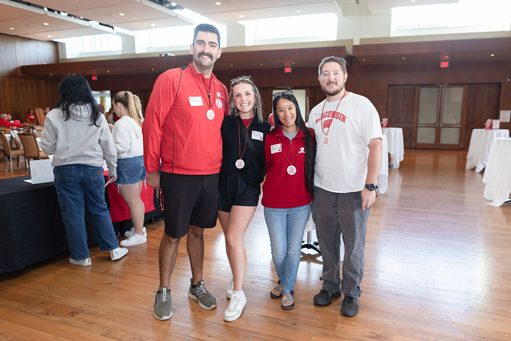 UW–Madison School of Pharmacy 2024 Alumni Tailgate and Watch Party Harold Barker, Madison Wiarek, Stephaney Cheng, and another alum pose for a photo in Badger gear