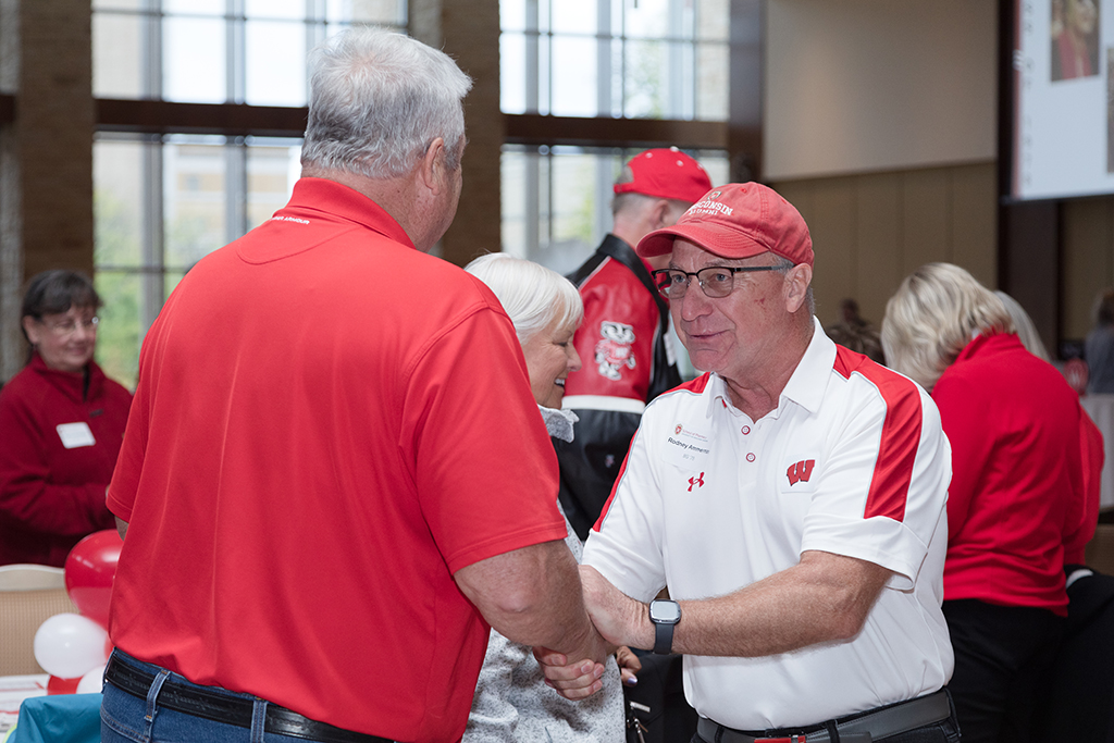 School of Pharmacy Alumni Tailgate Party 2023 Alumni shaking hands
