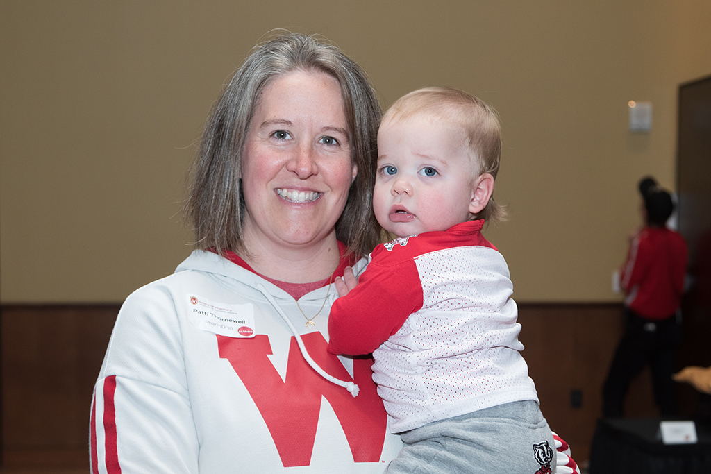 School of Pharmacy Alumni Tailgate Party 2023 Patti Thornewell holding her grandson in badger gear