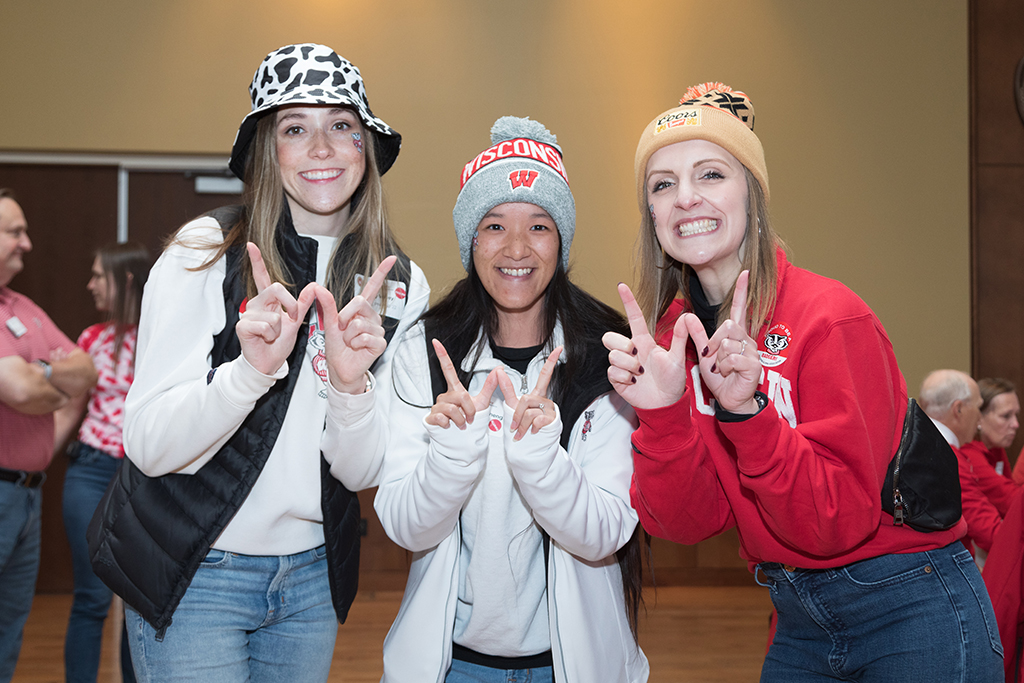 School of Pharmacy Alumni Tailgate Party 2023 Three alumni smiling and forming a "W" with their hands