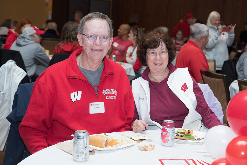 School of Pharmacy Alumni Tailgate Party 2023 Alumni David Hix eating with his wife at table
