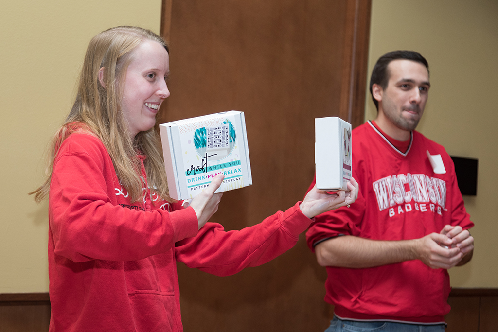 School of Pharmacy Alumni Tailgate Party 2023 student holding up craft boxes for raffle