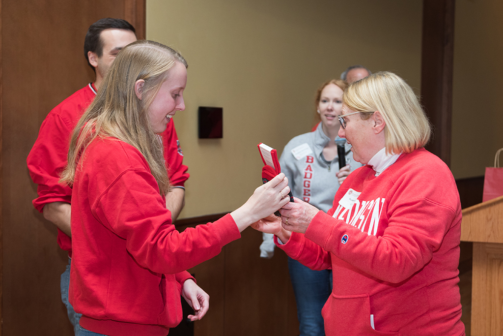 School of Pharmacy Alumni Tailgate Party 2023 Student giving red socks to raffle winner