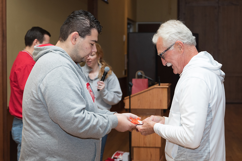 School of Pharmacy Alumni Tailgate Party 2023 Student delivering prize item to raffle winner