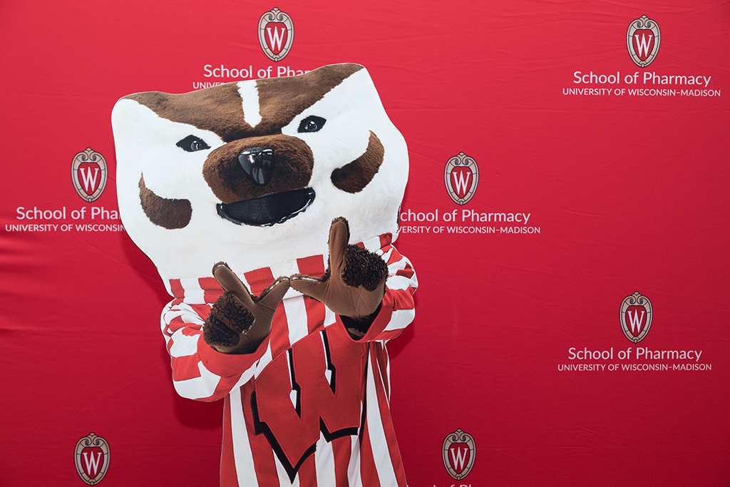 School of Pharmacy Alumni Tailgate Party 2023 Bucky Badger cardboard cutout in front of School of Pharmacy red backdrop