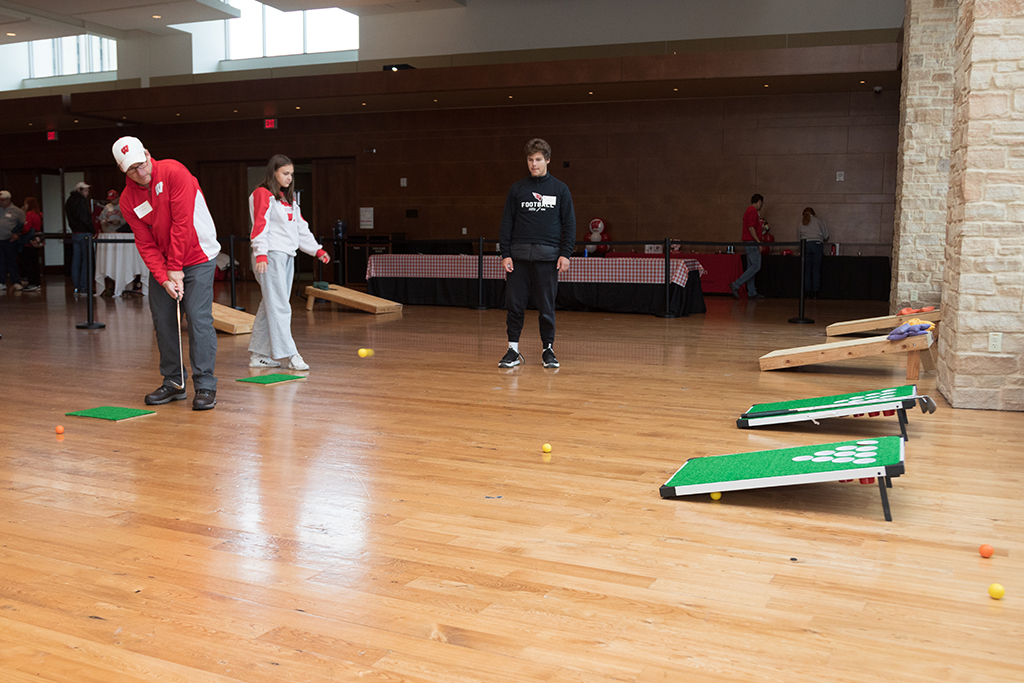 School of Pharmacy Alumni Tailgate Party 2023 Alumni playing cornhole and golf with boards set up