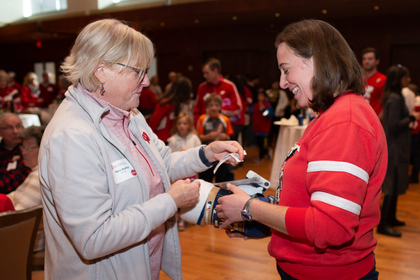 phar110919_070 Woman giving ticket to staff for blanket she won at Alumni Tailgate & Viewing Party