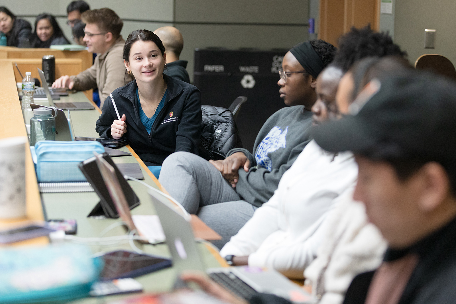 A row of PharmD students speaking in a lecture hall