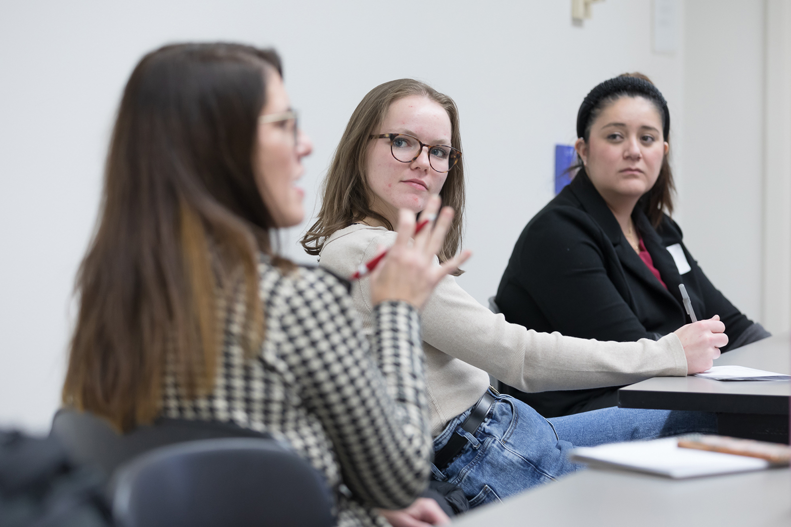 A side view of Lisa Imhoff speaking with two PharmD students