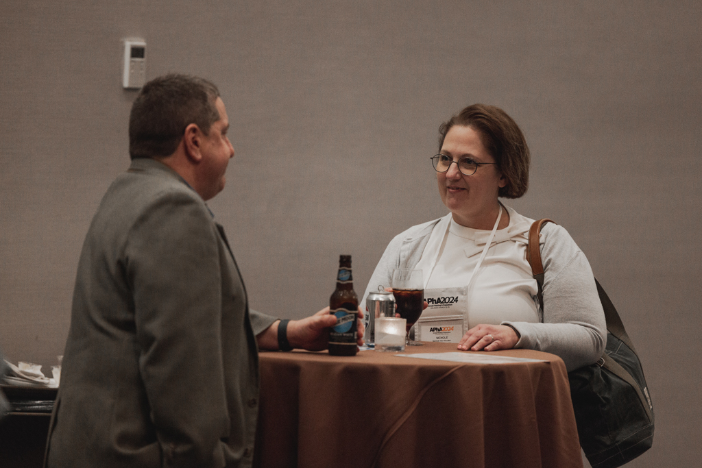 pharma0276_ Two attendees chat at a table