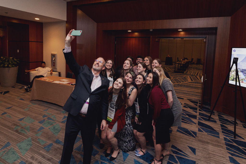 Advancement Dean Dave Mott takes a photo with a group of student alumni attendees of the APhA 2024 Alumni and Friends Reception.