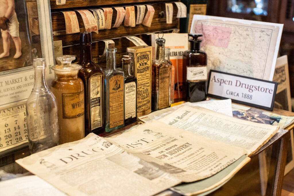 real-life-photographs-03 Aged glass bottles from Aspen Drugstore, circa 1888, and a Druggist newspaper.