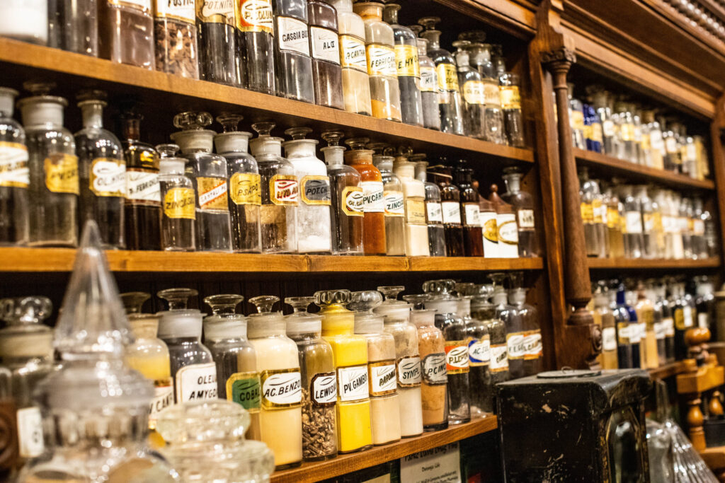 real-life-photographs-14 Long wooden shelves filled with glass pharmaceutical jars with gold-leafed labels.