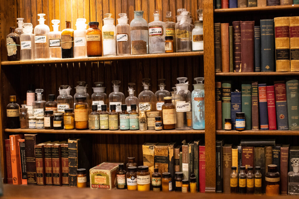 real-life-photographs-40 A shelf of old glass prescription bottles and books.