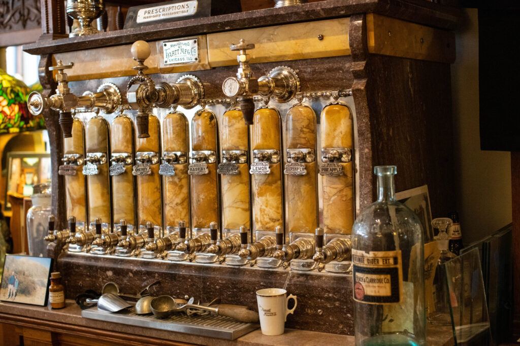real-life-photographs-41 A marble soda fountain with flavors like lemon, raspberry, sarsaparilla, pineapple, and more.