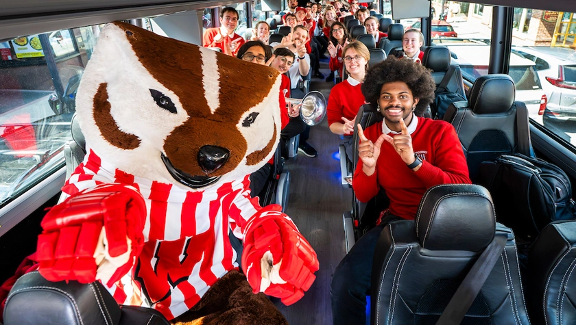Bucky Badger and UW Band members pose together on a bus