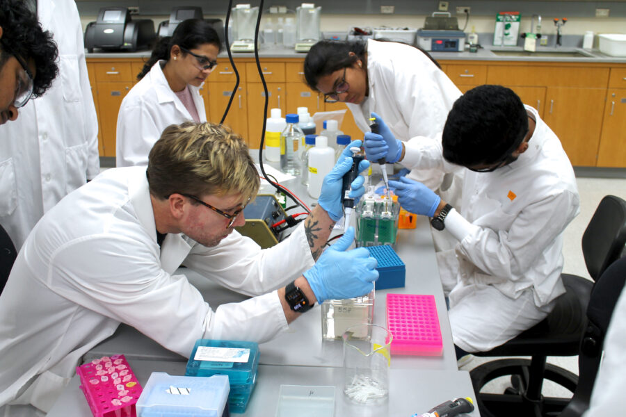 An ADD student pipettes solution into an electrophoresis gel