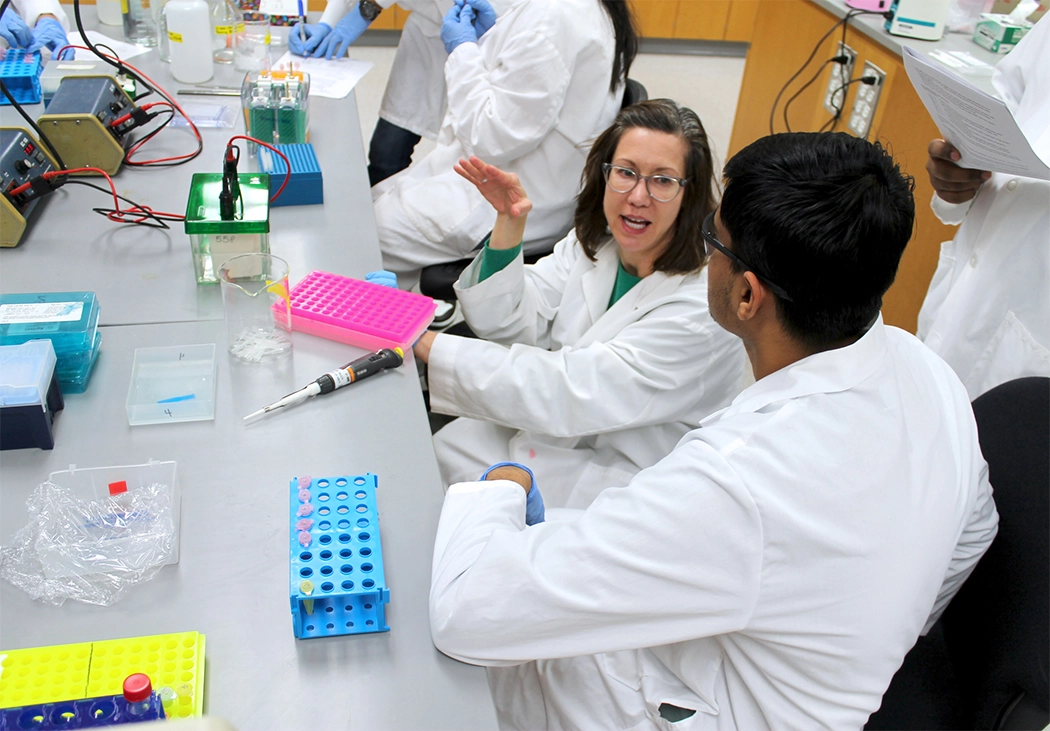 A student adjusts the settings on his pipette as he prepares a sample