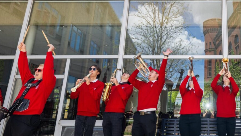 UW Band members dressed in festive red sweaters play a fanfare outside Memorial Union