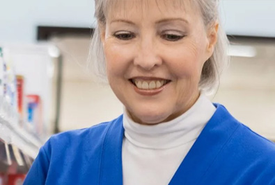 a senior woman visiting a pharmacy peruses medications