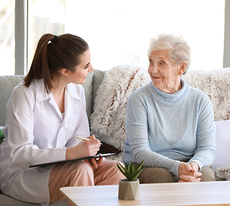 A pharmacist chats with an elderly patient to better understand how her medication regimen is going