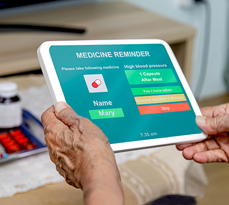 a patient holds an iPad with a medication reminder app